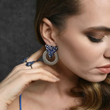 Statement luxury earrings adorned with blue gemstones.